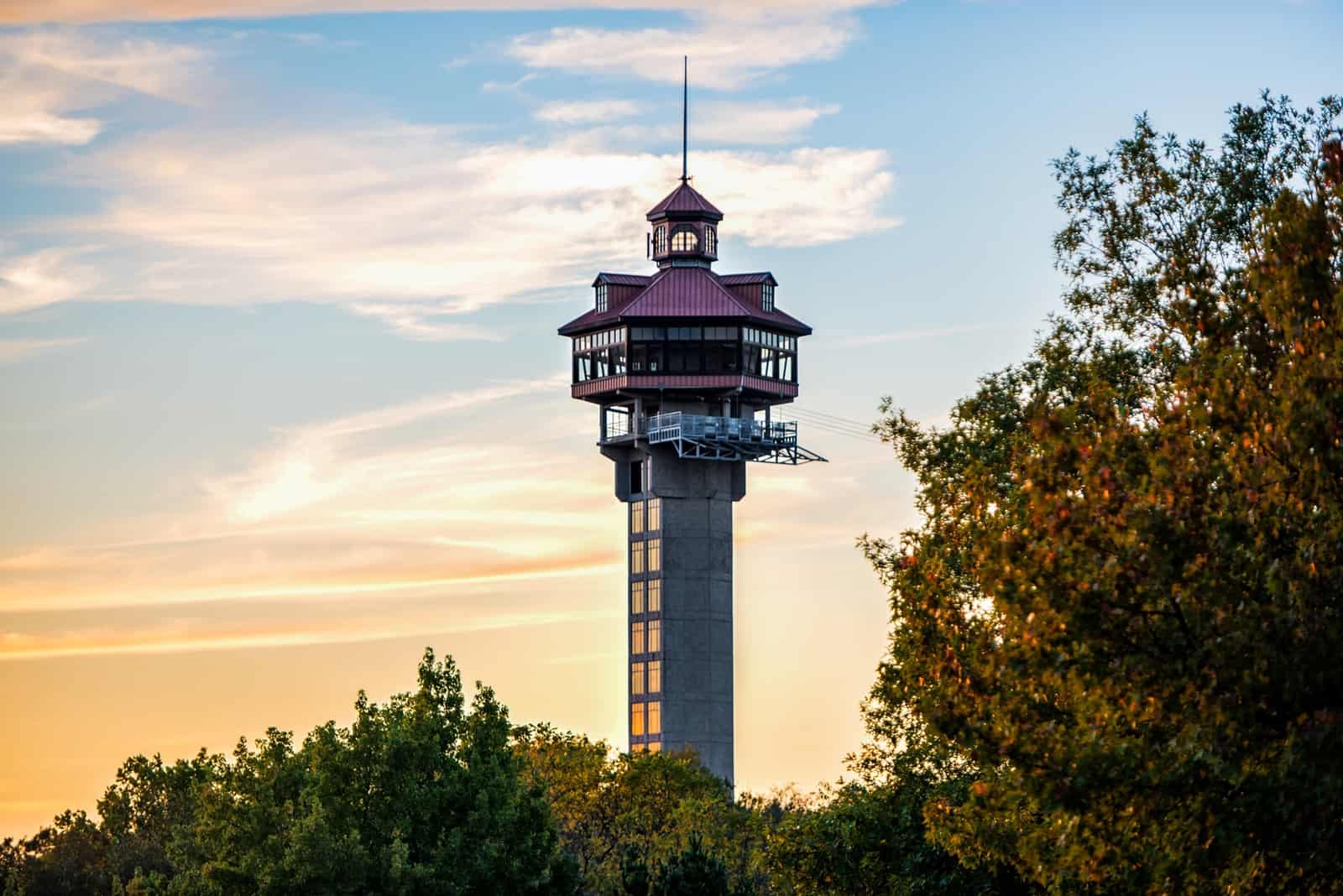 Inspiration Tower rising above the Ozark treetops at sunset.