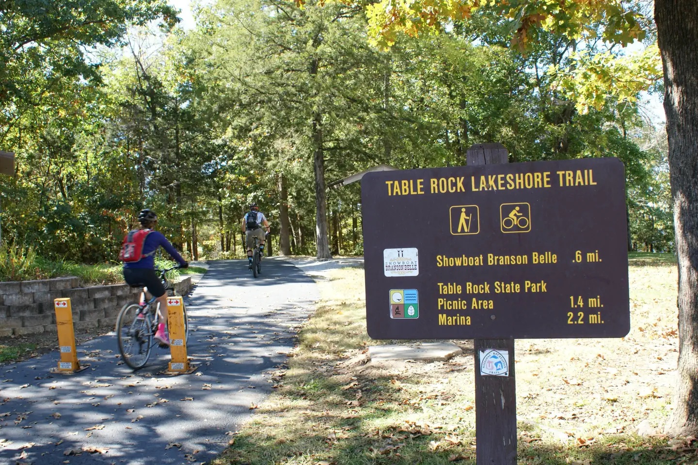 Cyclists entering the wooded Table Rock Lakeshore Trail.